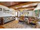 Cozy living room with wood-beamed ceilings, comfortable seating, and large windows at 9210 County Road 48, Yalaha, FL 34797