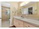 Well-lit bathroom featuring a vanity with storage and a shower with a glass door at 9951 Se 175Th St, Summerfield, FL 34491