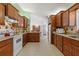 Spacious kitchen featuring wood cabinets, tile backsplash, and a view into the dining area at 9951 Se 175Th St, Summerfield, FL 34491