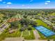 Expansive aerial view showcasing community amenities, including tennis courts, a pond, and recreation center at 10347 Se 179Th St, Summerfield, FL 34491