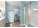 Bathroom featuring a white vanity, a large mirror, blue walls and a stand-up shower at 10347 Se 179Th St, Summerfield, FL 34491