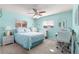 Comfortable bedroom with blue walls, carpet flooring, featuring a ceiling fan and a small workspace at 10347 Se 179Th St, Summerfield, FL 34491