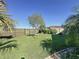 Lush backyard with a well-maintained lawn, trees, and a fenced perimeter offering privacy and security at 113 Bayou Bend Rd, Groveland, FL 34736