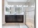 Modern bathroom featuring a double vanity with dark cabinets and a glass-enclosed shower with a built-in seat at 113 Bayou Bend Rd, Groveland, FL 34736