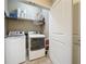 Functional laundry room with modern washer and dryer, ample storage shelves, and convenient access to the rest of the house at 113 Bayou Bend Rd, Groveland, FL 34736