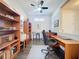 Spacious office featuring hardwood floors, a ceiling fan and ample shelving, creating a productive and organized workspace at 113 Bayou Bend Rd, Groveland, FL 34736