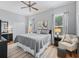 Nicely decorated bedroom featuring a large bed, area rug, ceiling fan and two large windows at 11735 Se 173Rd Lane Rd., Summerfield, FL 34491