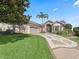 Inviting home exterior with a well-manicured lawn and patterned driveway, with a large tree at 11735 Se 173Rd Lane Rd., Summerfield, FL 34491