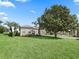 Landscaped front lawn with beautiful mature tree and green grass surrounding a well-maintained home at 11735 Se 173Rd Lane Rd., Summerfield, FL 34491