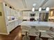 Sunlit kitchen showcasing white cabinets, stainless appliances, and a spacious quartz countertop island at 122 Tamarisk Way, Leesburg, FL 34748