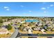 Enjoy a beautiful aerial view of a property in a tranquil neighborhood with lush landscaping, mature trees, and a nearby lake at 12455 Se 92Nd Ter, Summerfield, FL 34491
