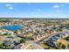 A beautiful aerial view of a property surrounded by lush landscaping in a neighborhood with a pond and mature trees at 12455 Se 92Nd Ter, Summerfield, FL 34491