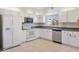 Bright kitchen featuring white appliances, cabinets, and tile flooring at 12455 Se 92Nd Ter, Summerfield, FL 34491