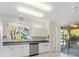 Bright kitchen featuring white cabinets, stainless steel appliances, and a sliding door to the lanai at 12455 Se 92Nd Ter, Summerfield, FL 34491