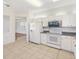 Bright kitchen with modern appliances, tile floor, and a view into another room at 12455 Se 92Nd Ter, Summerfield, FL 34491