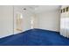 Main bedroom with adjacent bath and blue carpeting at 12455 Se 92Nd Ter, Summerfield, FL 34491