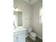Bathroom featuring a modern vanity, toilet, and large mirror, with natural light from the window at 14365 Crest Palm Ave, Windermere, FL 34786