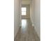 Hallway with tiled floors, neutral walls, and a bright window at the end, creating an airy feel at 14365 Crest Palm Ave, Windermere, FL 34786