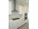 Kitchen with stainless steel range hood, electric cooktop, and white cabinets, exuding modern elegance at 14365 Crest Palm Ave, Windermere, FL 34786