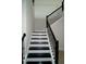 Stylish staircase featuring black and white steps and a sleek black railing at 14365 Crest Palm Ave, Windermere, FL 34786