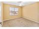 Neutral bedroom with beige carpet, large window, ceiling fan, and simple design at 1555 Ward Ct, The Villages, FL 32162