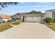 Charming single-story home features a wide driveway and a two-car garage at 1555 Ward Ct, The Villages, FL 32162