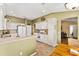 The kitchen features white cabinetry and a breakfast bar for casual dining at 1555 Ward Ct, The Villages, FL 32162