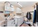 Well-organized laundry room with sink, modern washer, dryer and storage cabinets at 1555 Ward Ct, The Villages, FL 32162