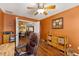 Cozy home office with warm color palette, wood floors, and open doorway to dining room at 1555 Ward Ct, The Villages, FL 32162