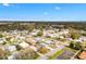 Bright aerial view of a single-story home in a vibrant residential community with lush landscaping and mature trees at 1616 Bayhill Dr, The Villages, FL 32159