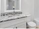Bathroom featuring a white vanity with granite countertop, modern faucet, and a matching toilet at 1616 Bayhill Dr, The Villages, FL 32159
