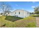 Exterior side view of a light yellow home with green lawn and blue skies at 1616 Bayhill Dr, The Villages, FL 32159