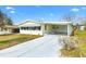 Charming single-story home with a covered carport and well-maintained lawn, offering comfort and convenience at 1616 Bayhill Dr, The Villages, FL 32159