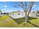 Side view of a yellow home with well-maintained lawn and mature trees at 1616 Bayhill Dr, The Villages, FL 32159