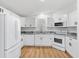Modern kitchen featuring white cabinets, new appliances, granite countertops, and wood flooring at 1616 Bayhill Dr, The Villages, FL 32159