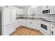 Modern kitchen featuring white cabinets, new appliances, granite countertops, and wood flooring at 1616 Bayhill Dr, The Villages, FL 32159
