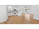 Open layout combines kitchen and living area with modern appliances, white cabinets, and wood flooring at 1616 Bayhill Dr, The Villages, FL 32159