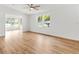 Bright living room with light wood floors, white walls, and a ceiling fan at 1616 Bayhill Dr, The Villages, FL 32159