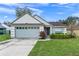 One-story house with attached garage, well-manicured lawn, and attractive landscaping at 167 N Cervidae Dr, Apopka, FL 32703