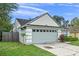 Charming home exterior features a two-car garage and a well-maintained front yard with mature trees and manicured landscaping at 167 N Cervidae Dr, Apopka, FL 32703