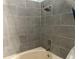 A tiled shower and bath combination features attractive gray tiling and modern fixtures at 167 N Cervidae Dr, Apopka, FL 32703