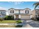 Charming two-story home featuring a well-manicured lawn and an attached two-car garage at 16825 Sunrise Vista Dr, Clermont, FL 34714