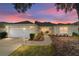 Inviting exterior featuring a two-car garage and well-manicured landscaping at 17145 Se 93Rd Yondel Cir, The Villages, FL 32162