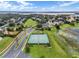 Aerial view of community featuring tennis court, playground, and lake access at 17523 Promenade Dr, Clermont, FL 34711