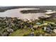Aerial view of a lakeside community with beautiful homes and mature trees at 17523 Promenade Dr, Clermont, FL 34711