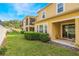 Grassy backyard, showing a manicured bush, and building exterior at 17523 Promenade Dr, Clermont, FL 34711