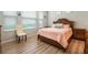 Bedroom featuring wood floors, neutral walls, and a bed with stylish headboard at 17523 Promenade Dr, Clermont, FL 34711