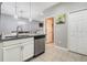 Kitchen space with stainless steel dishwasher, granite countertop, and tiled flooring at 17523 Promenade Dr, Clermont, FL 34711