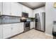 Well-lit kitchen featuring stainless steel appliances, white cabinets, and granite countertops at 17523 Promenade Dr, Clermont, FL 34711