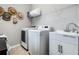 Bright laundry room with modern washer and dryer units, and a utility sink at 17523 Promenade Dr, Clermont, FL 34711